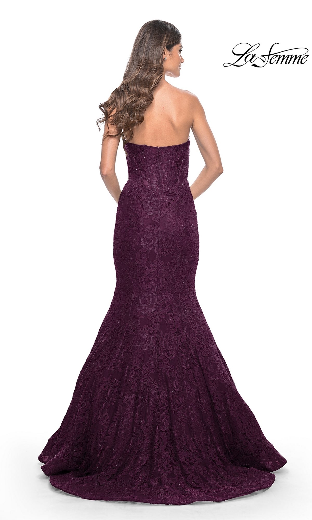 Woman in the La Femme Strapless Long Mermaid Prom Dress 32249, a floor-length dark purple beaded lace gown with a fitted bodice and flared hem, shown from the back.